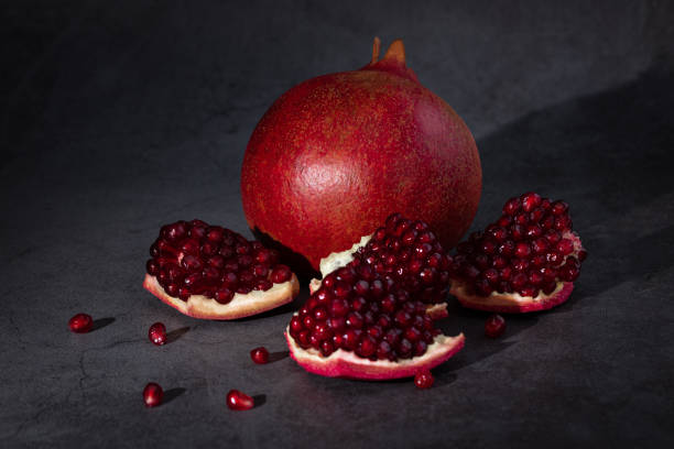 istock Ripe pomegranate fruits on a dark background 1203811842