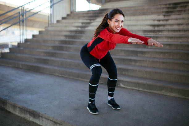 atleta femenina haciendo ejercicios en cuclillas al aire libre - running track women running spring fotografías e imágenes de stock