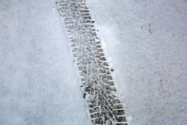 istock Traces of car wheels on white snow 1203813262