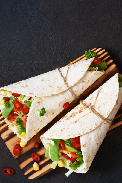 istock Mexican tortilla with beef, vegetables and chili on a dark background. 1203814778