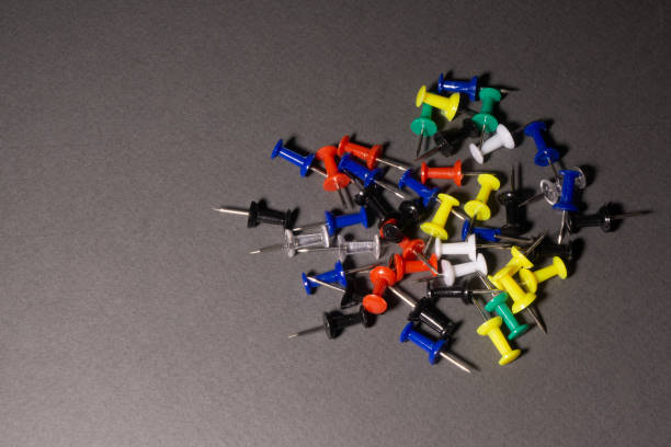 istock The push pins are multicolored scattered on a gray background. 1203815840
