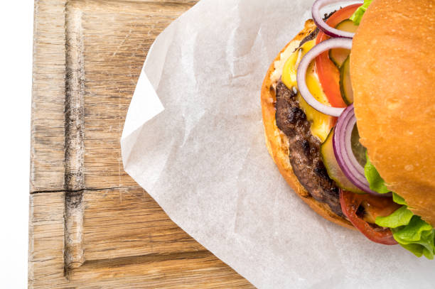 Tasty cheeseburger on a wooden board. Space for text Big tasty home made burger on a wooden board. Top view flat lay with copy space for your text pub table top view stock pictures, royalty-free photos & images