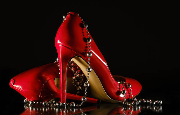 istock female red stilettos and beads on a black background 1203818990