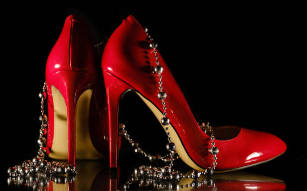 istock female red stilettos and beads on a black background 1203818995