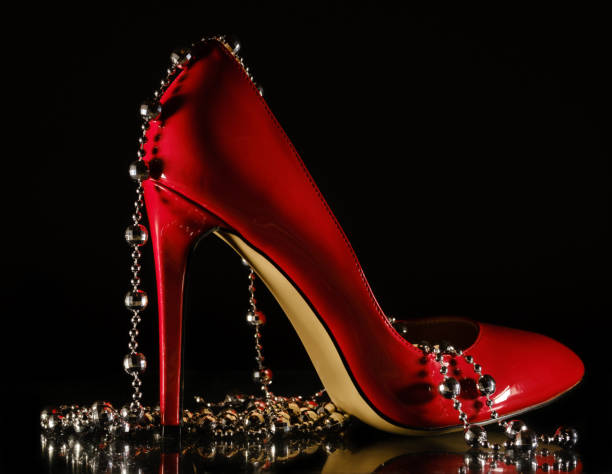 istock female red stilettos and beads on a black background 1203819018