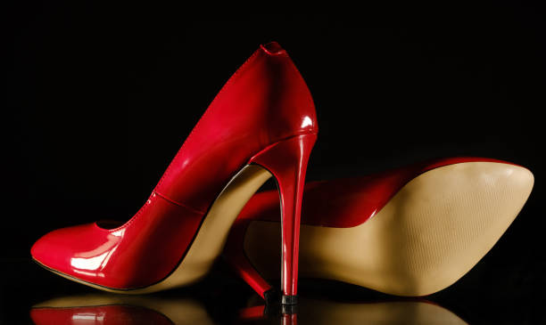 patent leather shiny female red stilettos on a black background