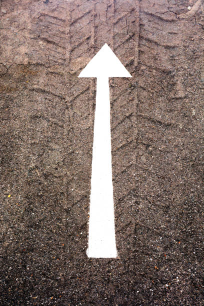 istock white arrow sign on the dry soil, ground, background 1203821082