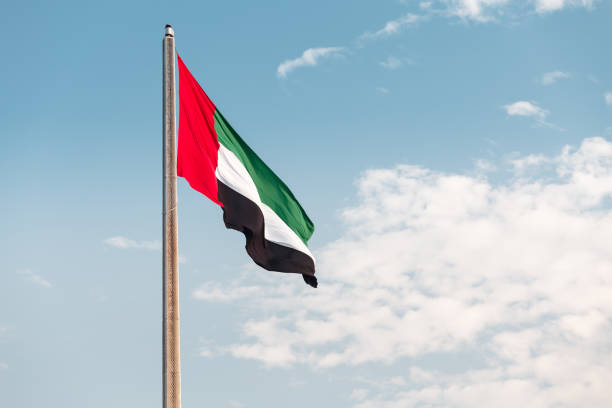 istock United Arab Emirates flag at blue sky background 1203821356