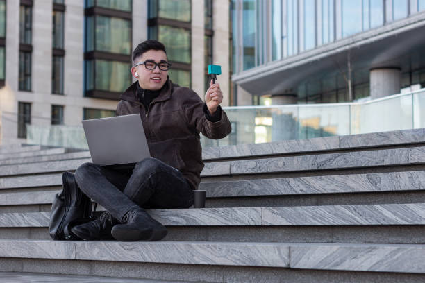 young male Asian blogger makes a selfie captures a vlog communicates subscribers