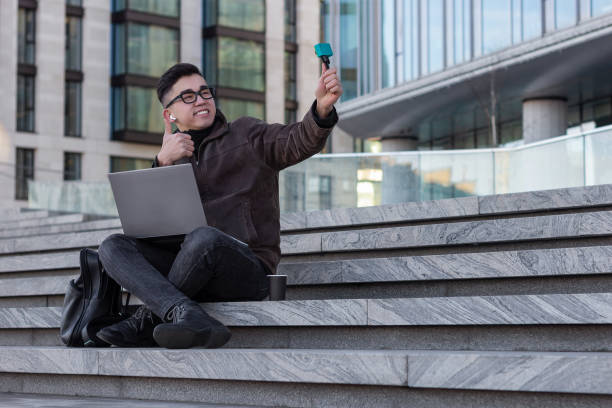 istock young male Asian blogger makes a selfie captures a vlog communicates subscribers 1203821601