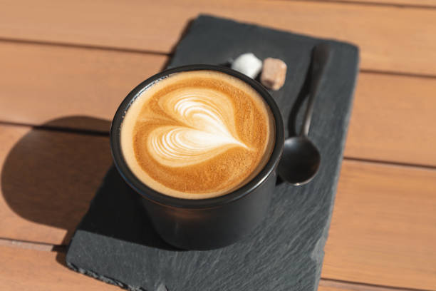 istock Cappuccino coffee with heart shape foam on a table in cafe 1203821717