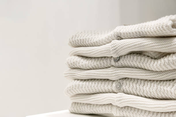 istock Beige sweaters made from natural fabrics are folded on the table. 1203823142