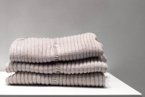 istock Beige sweaters made from natural fabrics are folded on the table. 1203823152