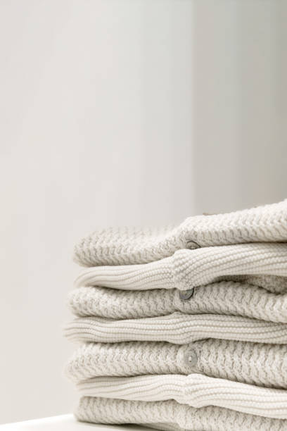 Beige sweaters made from natural fabrics are folded on the table.
