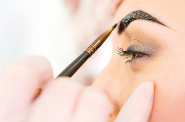 corrección de cejas, tratamiento de tinte de cejas primer plano. - coloreado a mano fotografías e imágenes de stock