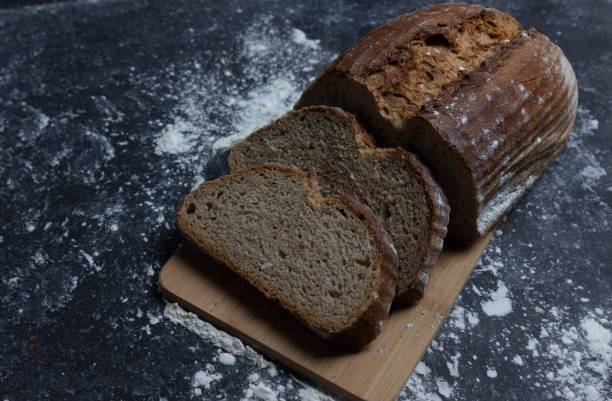 istock On a black background dark rye bread on a wooden board 1203824520