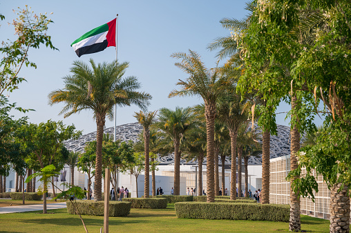 Palm trees and parkland surrounding the iconic Louvre Abu Dhabi in the United Arab Emirates.