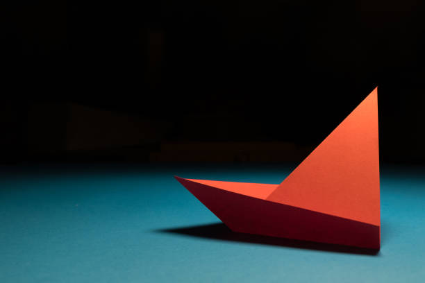 istock Explore: An origami sailing boat on a teal background 1203825868