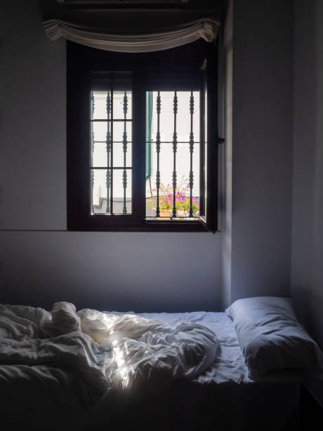 istock A room with a bed on which a ray of sun falls 1203826774