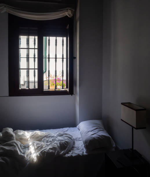 istock A room with a bed on which a ray of sun falls 1203826799