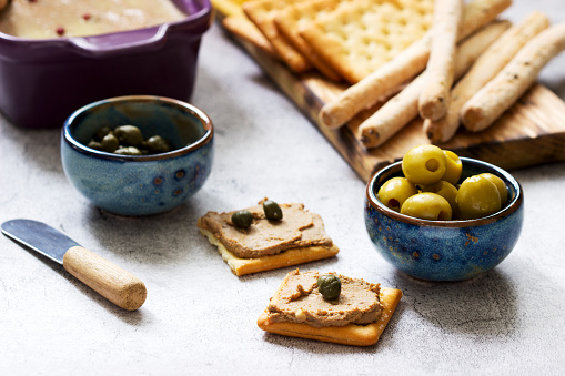 Chicken liver, onion and carrot paste, served with crackers, grissini, olives, capers and champagne. Selective focus.