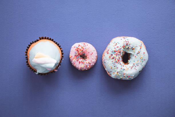Donuts on a colourful background two donuts and one cupcake with candy on top. top view picture