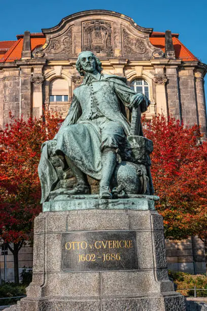 Photo of Statue of great scientist Otto Guericke in Magdeburg in red and golden Autumn colors, Germany