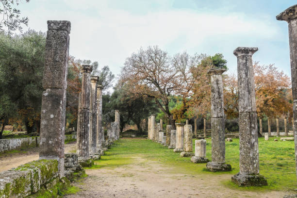 istock Columns found in ancient Olympia set on bases where the original athletes actually trained with winter trees in the background 1203831118