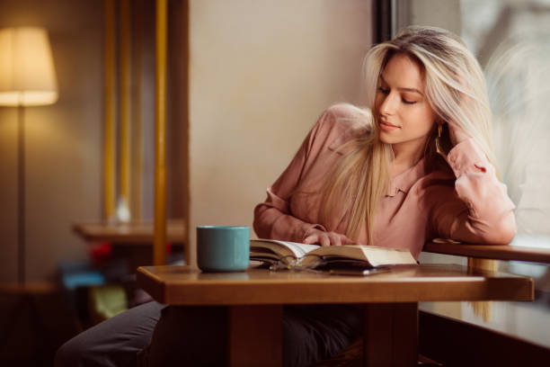 istock Beautiful woman reading a book 1203834735