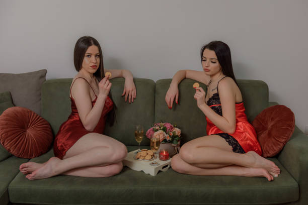 istock Young partial nudity women spend time together drinking white wine 1203836626