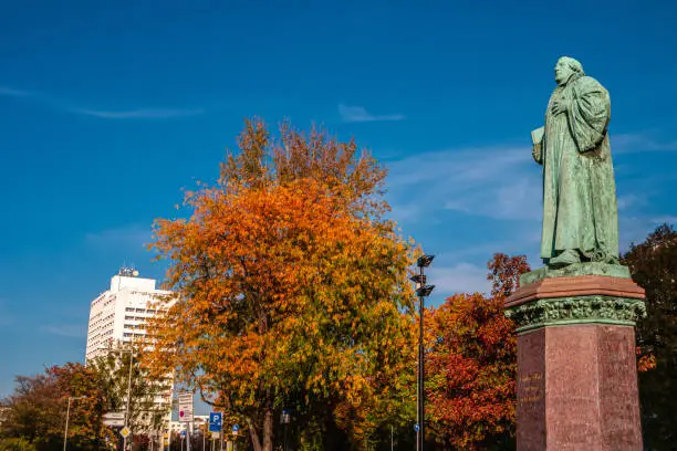 Photo of Statue of Martin Luther in Magdeburg downtown in golden Autumn colors and blue sky, Germany