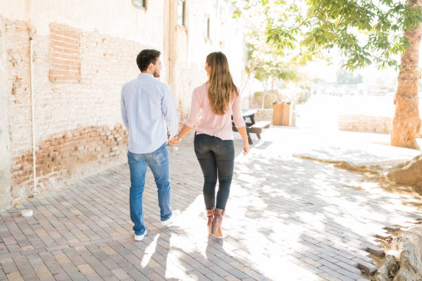 istock Latin Couple Walking On Footpath 1203839309