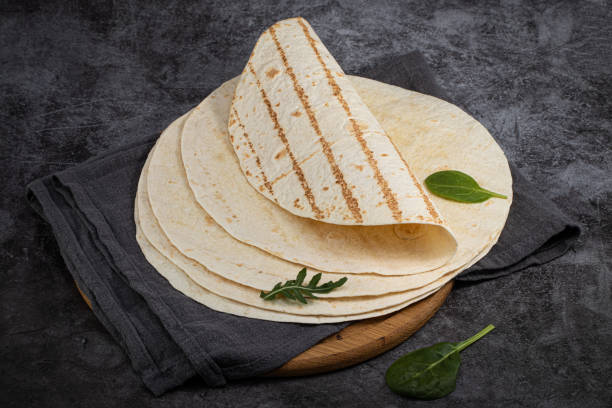 istock Stack of corn tortillas on dark background. Mexican food 1203839537