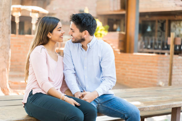 istock Smiling Romantic Couple Sitting Face To Face 1203840717