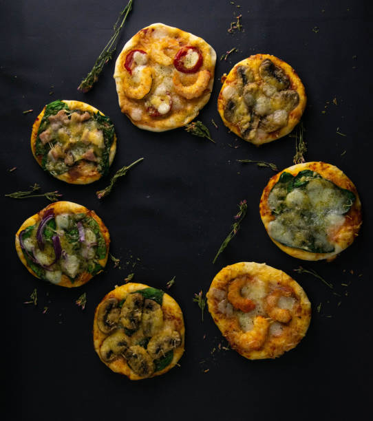 istock Small mini pizza. Set of different mini pizzas. Pizza: with shrimp, with mushrooms, with spinach and onions, with bacon, with paperoni, with tomatoes 1203841985