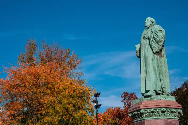 Photo of Statue of Martin Luther in Magdeburg downtown in golden Autumn colors and blue sky, Germany