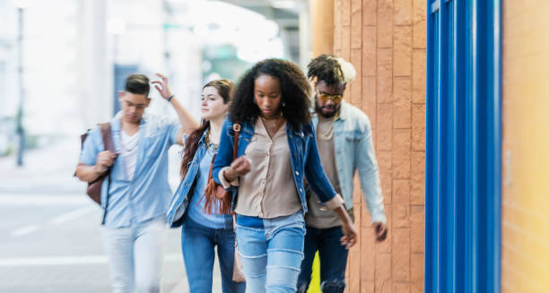 istock Multi-ethnic young adults walking in the city, strangers 1203843171