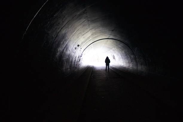 istock Black and white tunnel person silhouette 1203847351