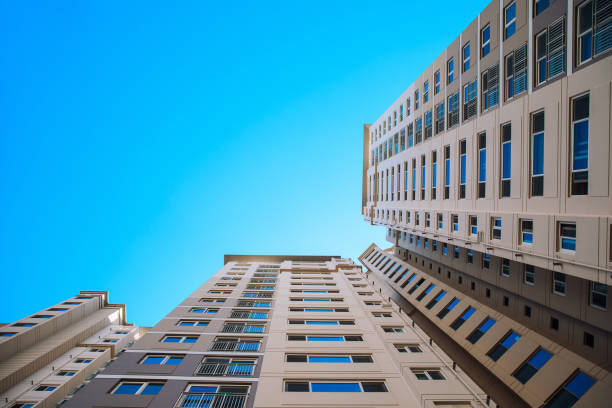 istock Low angle view of the apartment building against blue sky 1203848615