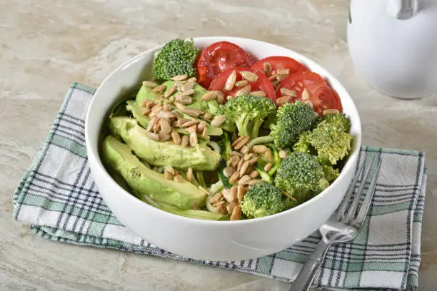 A delicious vegetable salad with avocado, julienned zucchini, broccoli crowns and tomato
