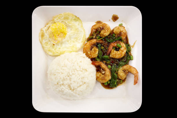 Basil fried rice, seafood, spicy flavor with fried egg on black background, focus selective.