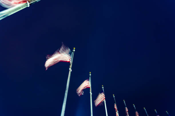 From below, American flags blowing in the wind. Motion blur.