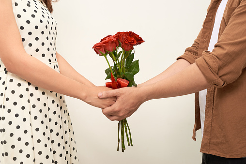 Young people holding a bouquet of roses bouquet in hand for a young girl lover, Romantic concept Caring for couples