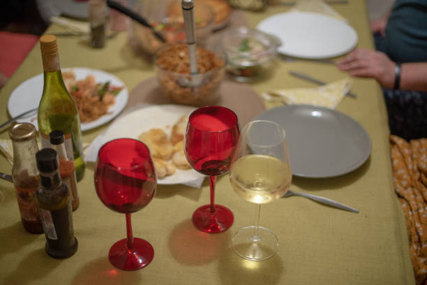 istock Wine glasses on table with food in background 1203877810