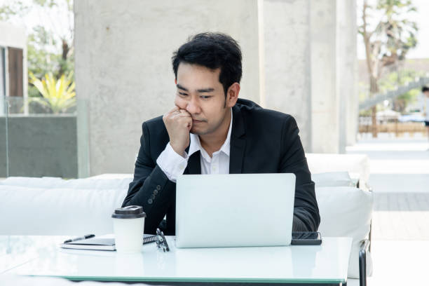 istock Stressed Asian businessman while working with laptop. 1203879904