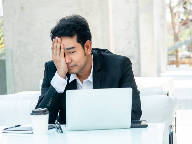istock Stressed Asian businessman while working with laptop. 1203879944