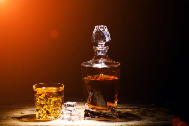 istock whiskey with ice cubes on wooden background 1203880043