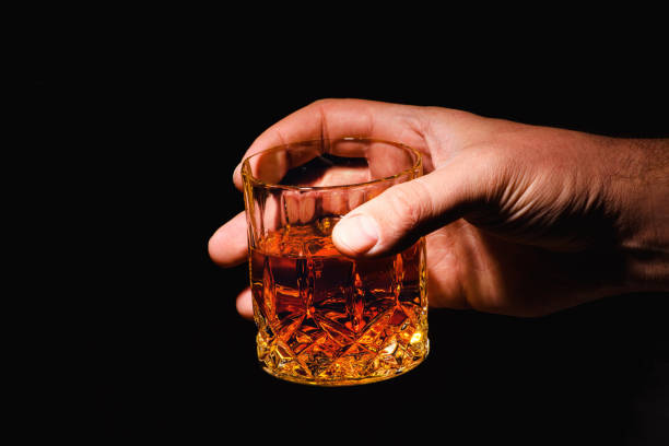 istock Whiskey glass in a hand of a man 1203880053