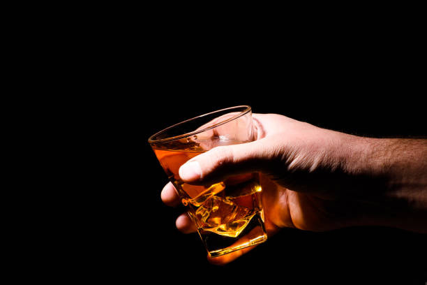 istock whiskey with ice cubes on wooden background 1203880057