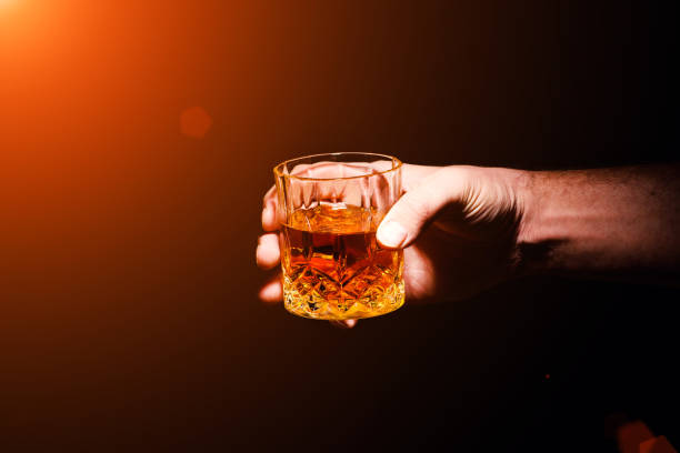 istock Whiskey glass in a hand of a man 1203880063